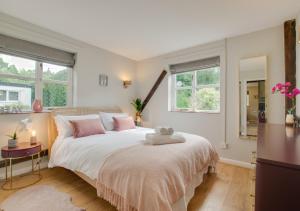 1 dormitorio con 1 cama grande con almohadas rosas en Perch Place en Kettleburgh
