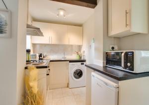 a kitchen with a microwave and a washer and dryer at Perch Place in Kettleburgh