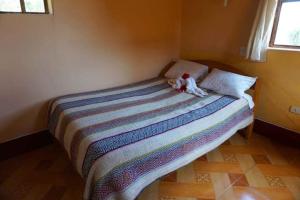 a bed with a stuffed animal sitting on top of it at Casa de Alejandra Llachon in Llachon