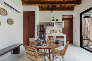 eine Küche und ein Esszimmer mit Tisch und Stühlen in der Unterkunft Luxury Villas in Aldea Zama in Tulum