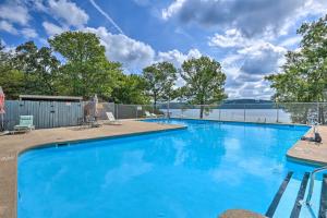 a large blue swimming pool with a view of a lake at Lush Garfield Cabin with Community Pool and Lake! in Garfield