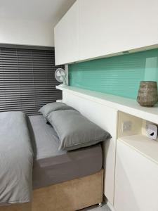 a small bed in a small room with a shelf at Orion building apartments ,OPOSITE GRAND CENTRAL,FREE CAR PARK in Birmingham