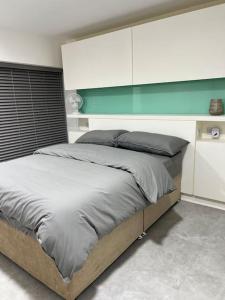 a bedroom with a large bed with a green wall at Orion building apartments ,OPOSITE GRAND CENTRAL,FREE CAR PARK in Birmingham