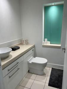 a white bathroom with a toilet and a sink at Orion building apartments ,OPOSITE GRAND CENTRAL,FREE CAR PARK in Birmingham