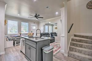 a kitchen and living room with a sink and a staircase at Bright Amarillo Townhome Near Parks and Town! in Amarillo