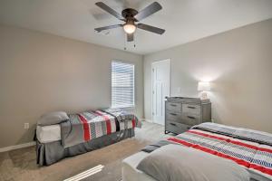 Bright Amarillo Townhome Near Parks and Town! في أماريلو: غرفة نوم بسريرين ومروحة سقف