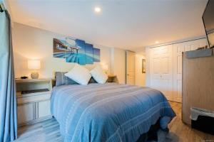 a bedroom with a bed with a blue comforter at Trails End Beach House suite with hot tub and beach bedroom cabin! in Ladysmith