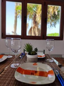 una mesa con un plato y copas de vino. en Apartamento Villa Alpispa, en Agüimes