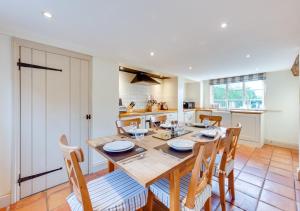 a kitchen and dining room with a wooden table and chairs at 1 Church Farm in Blythburgh