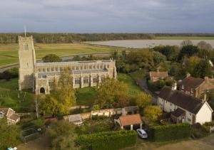 an aerial view of a large building with a church at 1 Church Farm in Blythburgh