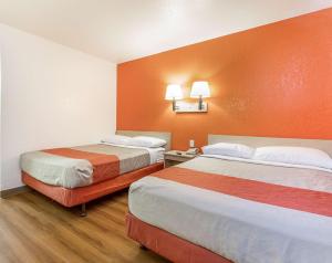 2 camas en una habitación de hotel con paredes de color naranja en Motel 6-Phoenix, AZ - North Bell Road en Phoenix