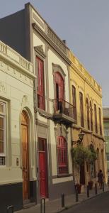 un gran edificio blanco con puertas y ventanas rojas en Adara Vegueta Exclusive Apartment, en Las Palmas de Gran Canaria