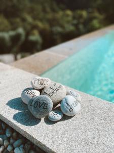 una pila de piedras con palabras sentadas junto a una piscina en Quinta do ribeiro, en Arcos de Valdevez