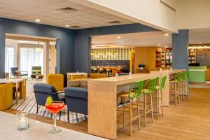 un vestíbulo con un bar con sillas y mesas en Sonesta Select Boston Foxborough Mansfield, en Foxborough