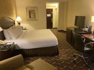 a hotel room with a bed and a desk and a television at Radisson Hotel Austin - University in Austin