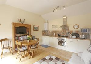 a kitchen with a table and a dining room at The Tack Room in Wangford