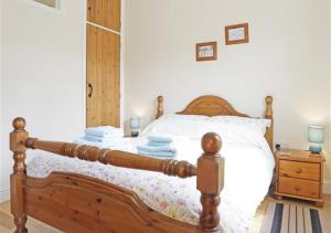 a bedroom with a wooden bed and a night stand at The Tack Room in Wangford