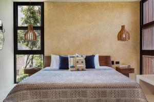 ein Schlafzimmer mit einem großen Bett mit zwei Fenstern in der Unterkunft Luxury Villas in Aldea Zama in Tulum + 21 Fotos