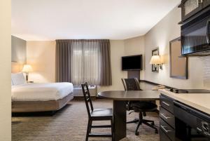 a hotel room with a bed and a desk at Sonesta Simply Suites Hampton in Hampton