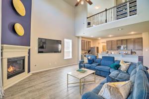a living room with blue couches and a fireplace at Houston Home with Private Yard - 16 Mi to Dtwn in Houston