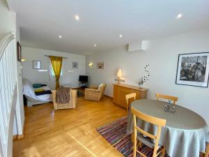 a living room with a table and a bedroom at Résidence De La Rance in La Richardais