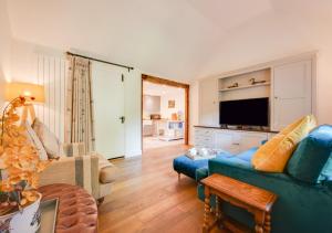 a living room with a blue couch and a tv at The Potting Shed 