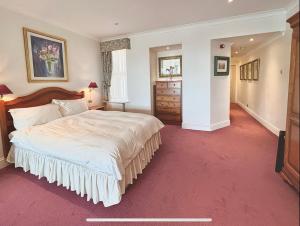 a bedroom with a large bed and a red carpet at Promenade House in Douglas