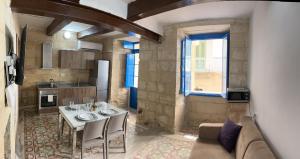 cocina con mesa y sofá en una habitación en Traditional Townhouse In The Hearth Of Valletta en La Valeta