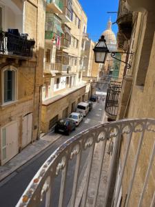 a view of a street with cars parked on the road at Traditional Townhouse In The Hearth Of Valletta in Valletta