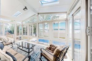 una sala de estar con ventanas y vistas al océano. en Malletts Bay Getaway, en Colchester