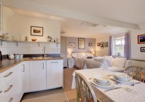 a kitchen and living room with a couch and a table at Garden Cottage The Old Mill in Snape