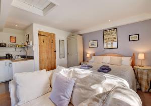 a bedroom with a large bed with white sheets at Garden Cottage The Old Mill in Snape