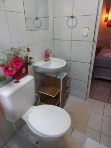 uma casa de banho com um WC branco e um lavatório. em Pousada Misticasa Fernando de Noronha em Fernando de Noronha