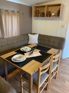 a table and chairs with a table and a couch at Impeccable 4-Bed Caravan in Clacton-on-Sea in Clacton-on-Sea