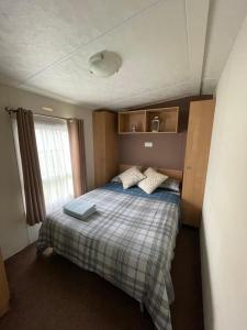 a small bedroom with a bed with two pillows at Impeccable 4-Bed Caravan in Clacton-on-Sea in Clacton-on-Sea