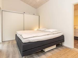 een bed in een witte kamer met bij 6 person holiday home in Hjørring-By Traum in Lønstrup