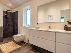 een badkamer met een wastafel, een toilet en een douche bij 6 person holiday home in Hjørring-By Traum in Lønstrup +32 foto's