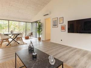 een woonkamer met een tafel en een tv bij 6 person holiday home in Hjørring-By Traum in Lønstrup
