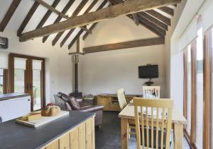 Stable Cottage Sternfield في Friston: مطبخ وغرفة معيشة مع طاولة وأريكة