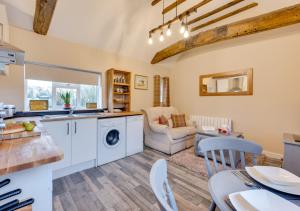 a kitchen and living room with a table and chairs at Ardley Cottage Hedgehog in Waldingfield
