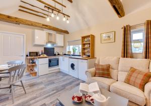 uma cozinha e sala de estar com um sofá e uma mesa em Ardley Cottage Hedgehog em Waldingfield