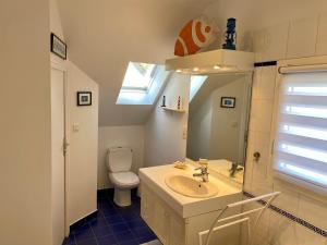een badkamer met een wastafel, een toilet en een raam bij Résidence De La Rance in La Richardais