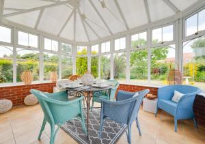 a conservatory with a table and chairs and windows at The Haven in Snape