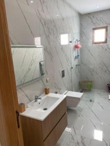 a white bathroom with a sink and a mirror at Ennakhil Garden in Marrakech