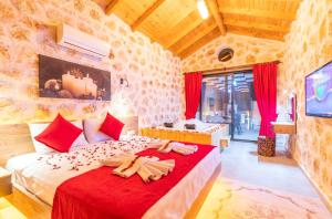 ein Schlafzimmer mit einem großen Bett mit roter Bettwäsche in der Unterkunft Havuzu dışarıdan görünmeyen jakuzili özel havuzlu lüks villa in Kalkan