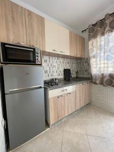 uma cozinha com um frigorífico de aço inoxidável e armários de madeira em Joli appartement au centre d'Oujda em Oujda