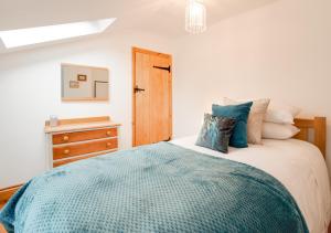 a bedroom with a bed and a wooden dresser at Lime Quay Cottage in Woodbridge