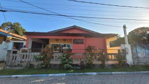una casa rosa con una valla delante en Pousada Aquário, en Isla de Boipeba
