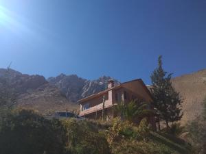 a house on a hill with mountains in the background at Hermosa casa familiar para 8 personas con tinaja-Cochiguaz Valle de Elqui in Paihuano