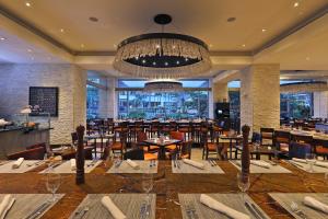 un restaurant avec des tables et des chaises et un lustre dans l'établissement InterContinental Costa Rica at Multiplaza Mall, an IHG Hotel, à San José